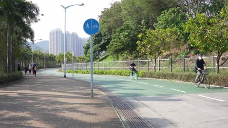 Bikes-and-pedestrians-at-Tseung-Kwan-O-Waterfront-Promenade,-Hong-Kong