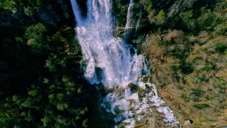 Aerial-Birds-Eye-View-Of-White-Water-Cascading-Waterfalls-Surrounded-By-Lush-Green-Trees