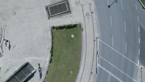 Aerial-drone-follow-some-tourists-visiting-the-marques-pombal-square-in-a-sunny-day,-Portugal