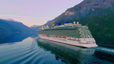 Aerial-view-of-cruising-cruise-ship-on-Norwegian-fjord-with-beautiful-landscape-in-backdrop