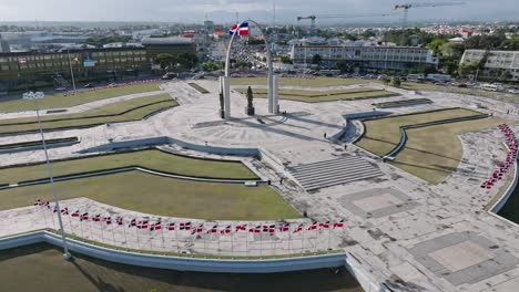 Aerial-Orbit-Shot-Of-Plaza-De-La-Bandera-In-Santo-Domingo-And-Waving-Flags