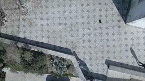 Luftaufnahme,-Die-Den-Konturen-Eines-Mosaiksterns-Folgt-Und-Die-Vielen-Kleinen-Fliesen-Und-Muster-Zeigt,-Die-Mit-Den-Weißen-Fliesen-In-Lissabon-Hergestellt-Wurden