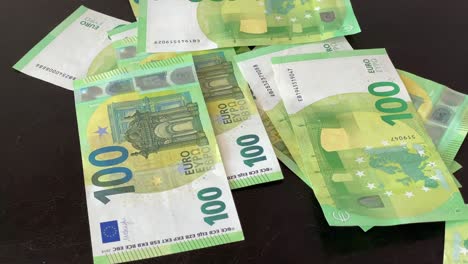 The-biggest-banknote-in-europe,-green-100-euro-fall-on-table