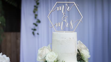 Beautiful-wedding-cake-decorated-with-natural-flowers-and-a-cake-topper-on-the-tip