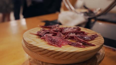 Slicer-serves-a-plate-of-Spanish-Serrano-ham