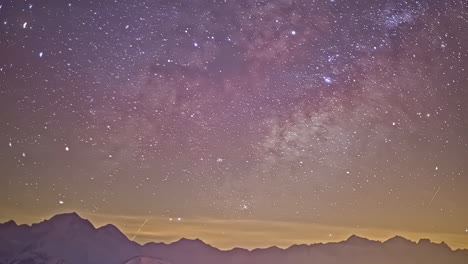 Time-lapse-shot-of-moving-stars-at-night-sky-with-flying-meteors-above-mountain-range-silhouette---wide-shot