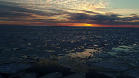 Aerial-flyover-melting-ice-floe-and-cubes-during-sunset-time-in-Iceland---Environmental-global-warming