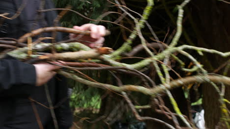 A-man-carrying-tree-brances-and-stick-in-the-woods