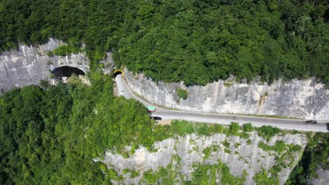 Aereal-footage-over-road-with-traffic-passing-through-breathtaking-forest,-high-altitude-and-winding-road-during-sunshine-day,-captured-at-Hebei-Province,-China