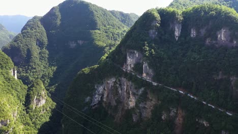 Amazing-view-aerial-footage-over-road-with-traffic-passing-through-the-breathtaking-forests,-high-altitude-and-winding-roads,-captured-in-Hebei-Province,-China