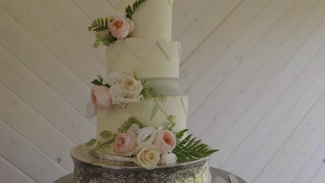Delicious-white-three-tier-wedding-cake,-decorated-with-natural-flowers