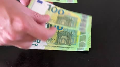 Männerhände-Zählen-100-Euro-Scheine