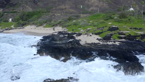 Man-standing-at-Makapuu-Oahu-Hawaii-rock-outcropping-as-waves-crash