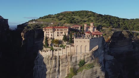 4K-Meteora-Monestary-Of-Varlaam,-Monestary-on-a-Mountain-Pan-Left,-Close-up---Aerial-Drone,-Μετέωρα,-Ελληνικά-Meteora-Greece,-Vertical-Rock-Formation,-Fall-colors,-Sunset,-Ancient-Greece,-Cinematic