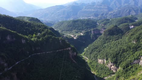 Stunning-aereal-footage-over-road-with-traffic-passing-through-breathtaking-forest,-high-altitude-and-winding-road,-captured-at-Hebei-Province,-China