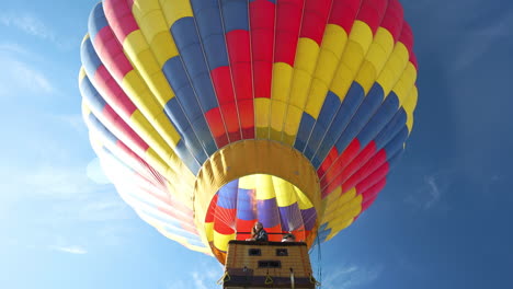 Hot-Air-Balloon-With-People-in-Basket-Rising-Up-Under-Sky,-Low-Angle-View