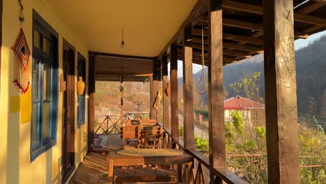 sunrise-wind-sun-light-the-balcony-terrace-of-a-local-wooden-house-cabin-in-the-fall-orange-yellow-autumn-color-in-forest-Iran-wooden-dining-table-offer-best-view-to-travel-north-nature-natural-park