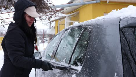 Woman-Cleaning-Car-From-Snow-After-Blizzard---closeup