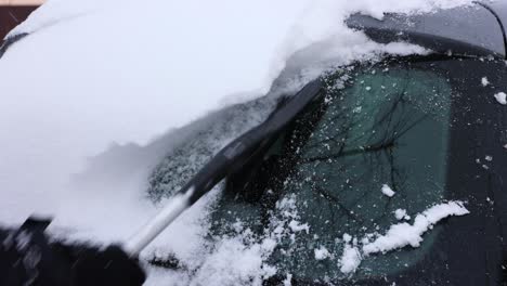 Woman-Hand-Cleaning-Snow-From-The-Car-In-Winter---close-up