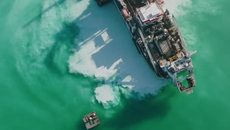 Close-up-aerial-footage-of-the-clouds-of-sand-and-dust-in-the-water-off-of-a-sand-dredging-ship