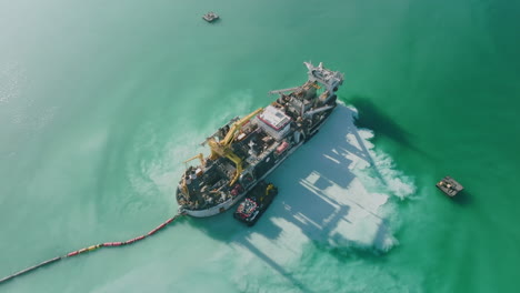 Aerial-footage-rotating-around-a-giant-sand-dredging-ship-in-the-harbor-outside-of-Bari,-Italy-in-the-Adriatic-Sea