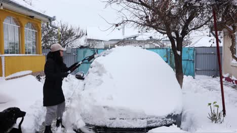 Woman-Removes-Snow-From-Car-With-Snow-Brush---wide