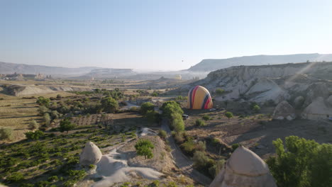 Hot-air-balloon-getting-deflated-after-flying-over-hills-during-sunset-in-Cappadocia