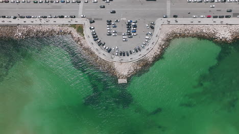 Static-top-down-aerial-of-a-fishing-and-viewing-spot-on-the-Adriatic-Sea-in-the-city-of-Bari,-Italy-with-cars-driving-by