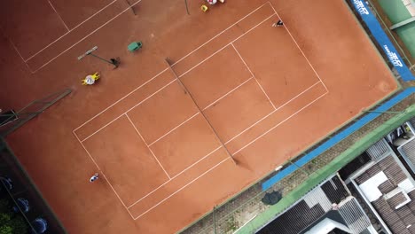 Birds-eye-drone-show-of-a-tennis-match-in-a-clay-court