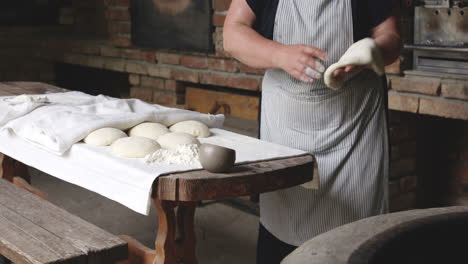 Woman-Baker's-Hands-Flatten-The-Dough-And-Sticks-It-On-The-Hot-Surface-Of-A-Round-Clay-Oven