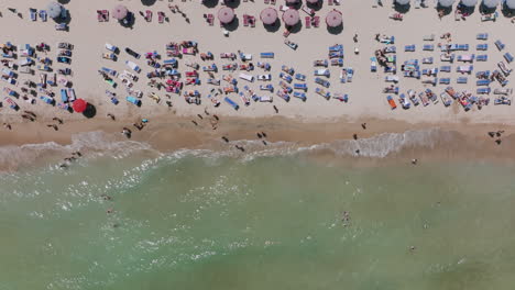 Top-down-aerial-footage-of-tourists-at-the-beach-in-Bari,-Italy-during-the-day