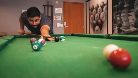 A-man-plays-billiards-hitting-the-white-cue-ball