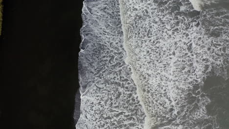 Luftaufnahme:-Luftaufnahme-Von-Oben-Nach-Unten-Auf-Wellen,-Die-Sich-Am-Vulkanischen-Schwarzen-Sandstrand-Brechen