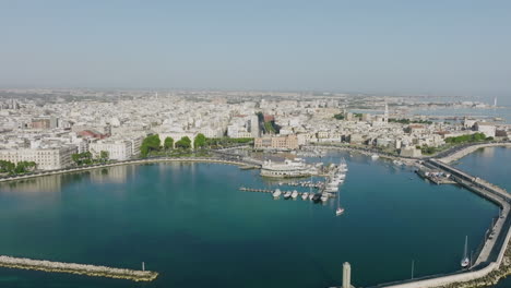 Aerial-footage-flying-over-a-marina-and-Circolo-Canottieri-Barion-Sporting-Club-in-Old-City-Bari,-Italy