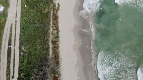 Overhead-View-Of-Waves-Rolling-Over-Sandy-Shore