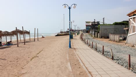 Malerische-Promenade-Am-Strand-Von-Vama-Veche-Mit-Strohgedeckten-Sonnenschirmen-An-Einem-Sonnigen-Sommertag-In-Constanta,-Rumänien