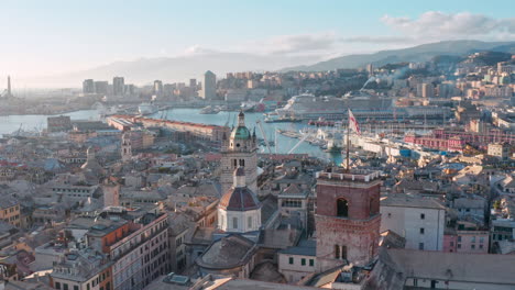 Scenic-aerial-view-over-rooftops-and-historic-towers-toward-Porto-Antico,-Genoa