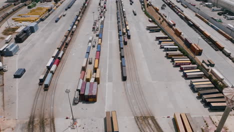 Slow-aerial-footage-of-shipping-containers-with-trucks-moving-containers-around