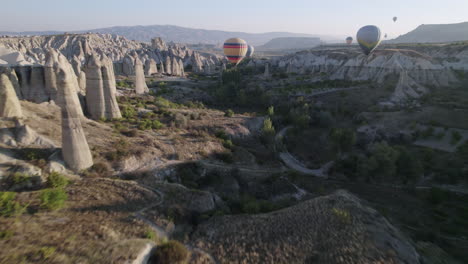 Heißluftballons-In-Kappadokien-Fliegen-Bei-Sonnenuntergang-über-Hügel