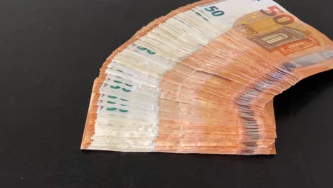 Stack-of-50-€-banknotes-on-table-is-fanned-out