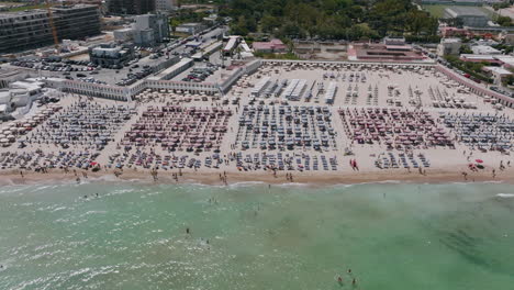 Aerial-footage-of-a-resort-and-people-at-the-beach-in-Bari,-Italy-during-the-day