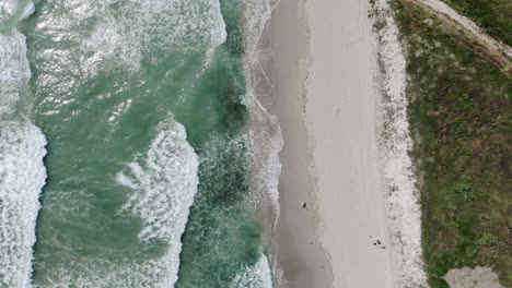 Aerial-Drone-View-Of-Foamy-Waves-Onto-White-Sandy-Shoreline