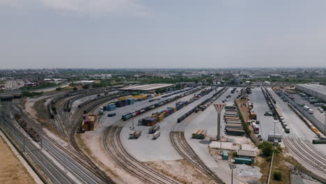 Wide-aerial-footage-of-a-industrial-logistics-center-with-trucks-moving-containers-around-in-Bari,-Italy