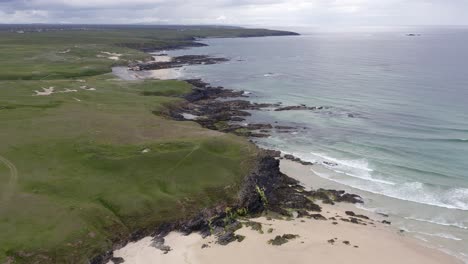 Drone-shot-of-Eoropie-beach-in-Ness-and-the-headland-beyond-it-on-a-sunny,-Summer's-day