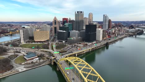 Aerial-drone-descending-shot-of-Pittsburgh-skyline-with-beautiful-light-on-winter-day