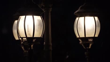 Lamps-of-street-lights-on-snowy-evening,-vintage-streetlamps-on-dark-night-background,-retro-copy-space