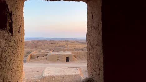 Beautiful-landscape-of-desert-splendid-wide-view-through-the-door-and-window-pomegranate-garden-rural-area-and-old-fashioned-architecture-design-of-traditional-ruin-house-by-earthquake-in-Iran-Nature