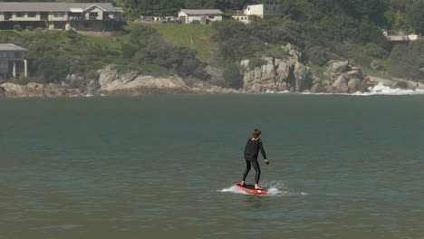 Young-man-enjoys-riding-Fliteboard-power-hydrofoil-surfboard-off-shore