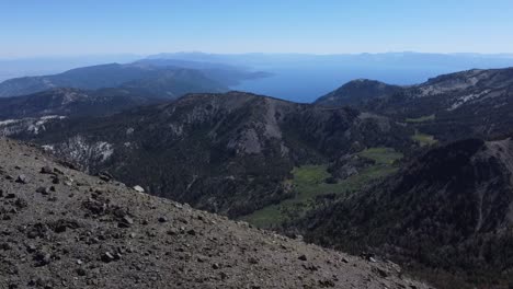 Aerial-reveal-shot-of-Lake-Tahoe-and-the-surrounding-mountains-from-the-summit-of-Mount-Rose