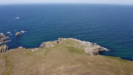 Drone-shot-of-a-lighthouse-surrounded-by-cliffs-and-nesting-sea-birds